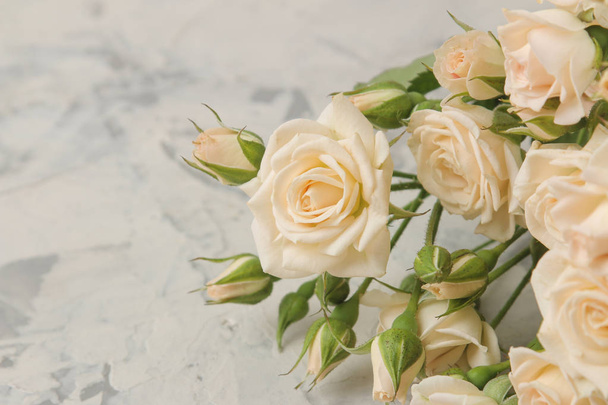 Un bouquet di bellissime mini rose teneri su uno sfondo di cemento chiaro. spazio per il testo
 - Foto, immagini