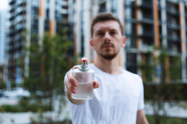 man with perfume. Happy man point finger at perfume bottle - Photo, Image