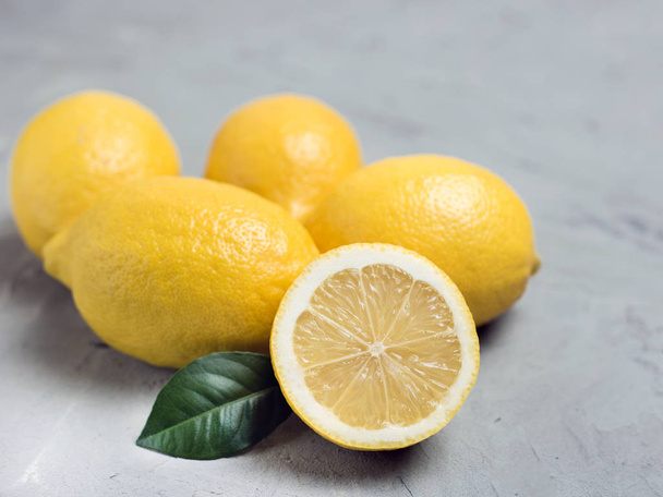 Lemons on gray stone background, copy space. Organic fresh citrus fruits - 写真・画像