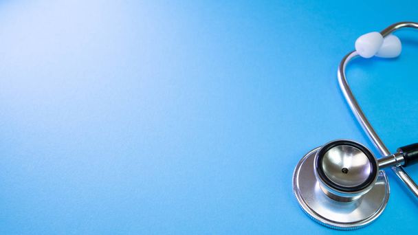 Медицинский стетоскоп сердца для осмотра врача в больнице или аптеке на синем фоне
 - Фото, изображение