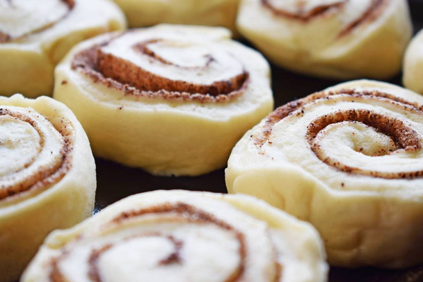 Prepare delicious cinnamon cookies.Dough rolled into a roll, cut into small pieces. - Foto, imagen