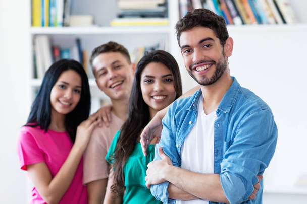 Spanish guy with group of friends in a row indoors at university - Foto, imagen