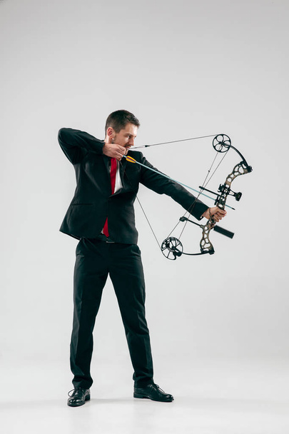 Businessman aiming at target with bow and arrow, isolated on white background - Zdjęcie, obraz