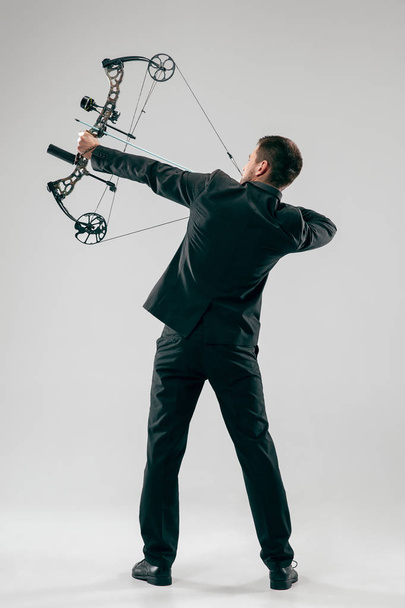 Businessman aiming at target with bow and arrow, isolated on white background - Фото, изображение