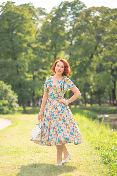 linda chica en vestido retro disfrutando de la vida en la ciudad Parque en verano
 - Foto, imagen