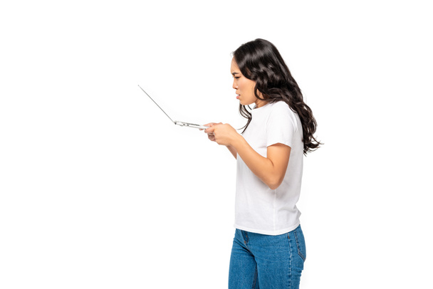 colère jeune asiatique femme en blanc t-shirt et bleu jeans à l'aide d'ordinateur portable isolé sur blanc
 - Photo, image