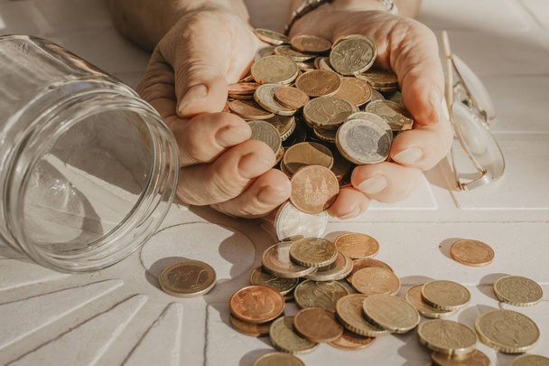 рука пенсионера с монетами и сбережениями в руках
 - Фото, изображение