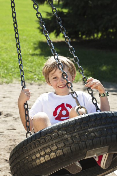 rozkošný chlapec houpání na houpačce pneumatiky - Fotografie, Obrázek