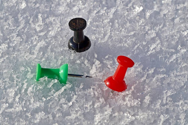 Pollice nei colori rosso, nero e verde isolato su fondo neve
 - Foto, immagini