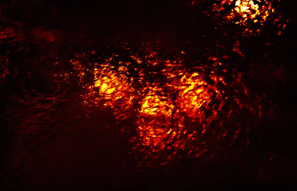 Αφηρημένη νερό grops με φόντο σκούρο κόκκινο δραματικό τόνο. Σταγόνες του νερού και πιτσίλισμα στο γυαλί - Φωτογραφία, εικόνα