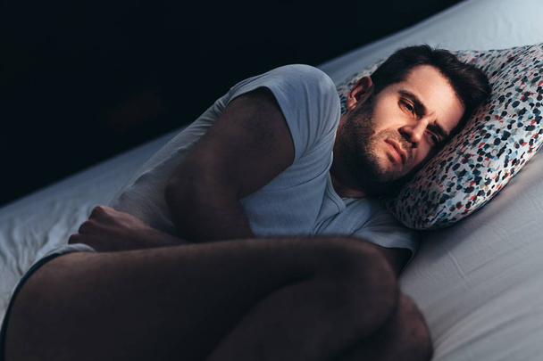 Jeune homme déprimé dans la douleur sur le lit
 - Photo, image