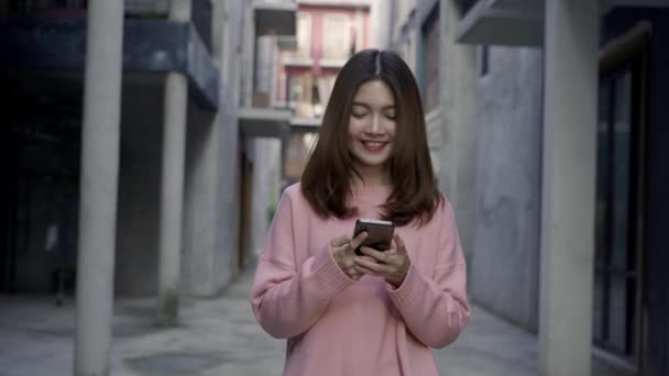 Slow motion - asijské turistické blogger žena pomocí smartphone pro směr a při pohledu na mapu umístění při cestování v čínské čtvrti v Pekingu, Čína. Lifestyle batoh turistické cestování dovolená concept. - Záběry, video