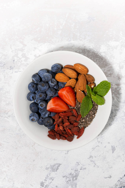 chia seeds, fresh berries and nuts for a healthy breakfast, top view - Photo, image