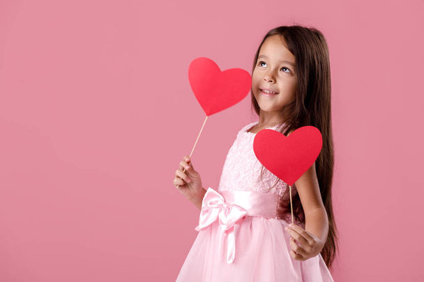 cute little girl in a pink dress holding a paper heart - Foto, imagen