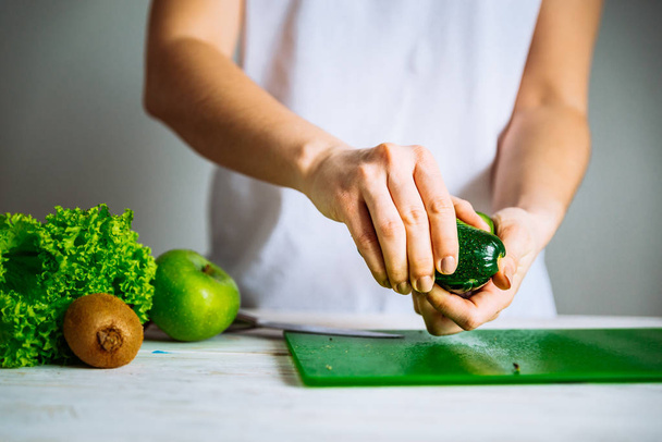 Una donna ha tagliato l'avocado. concetto di cibo sano. ingredienti per frullati
 - Foto, immagini