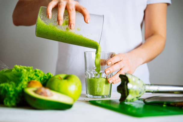 woman transfuse smoothie to glass. healthy food concept - 写真・画像