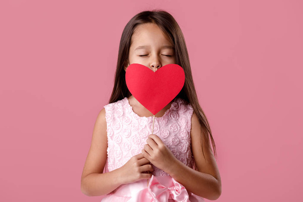 cute little girl in a pink dress holding a paper heart - Valokuva, kuva