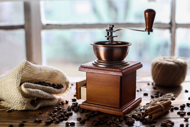 Manual coffee grinder on wooden table - Fotó, kép
