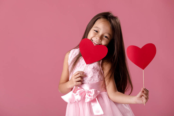 cute little girl in a pink dress holding a paper heart - Zdjęcie, obraz