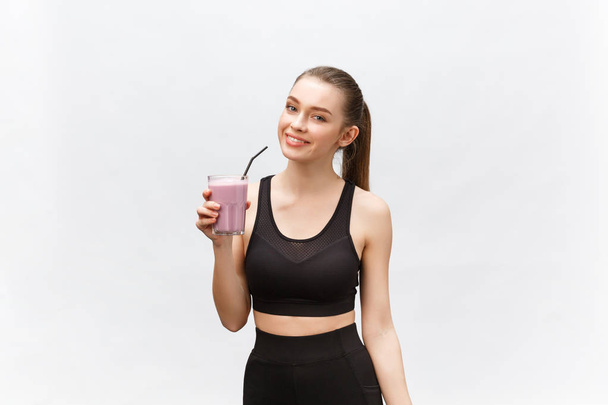 молодая счастливая женщина со здоровым питанием коктейль питьевой для спорта и фитнеса. - Фото, изображение