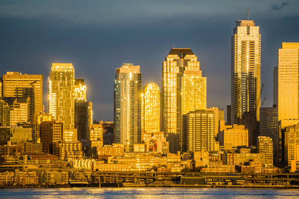 Zachodzące słońce odbija się od wieżowców w panoramę Seattle. - Zdjęcie, obraz