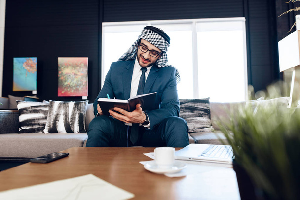 Arab businessman taking notes on couch at office room. - Φωτογραφία, εικόνα