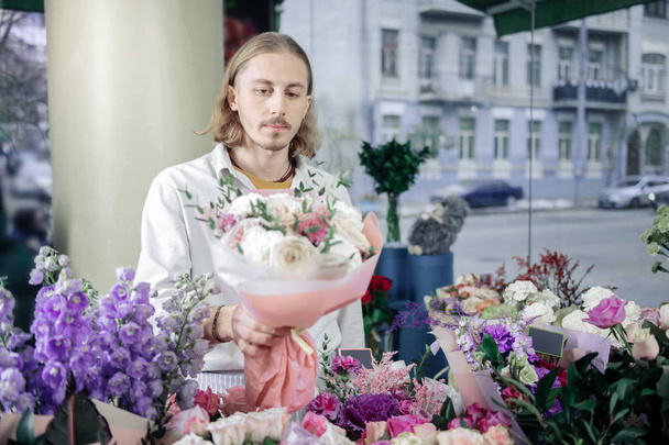 Attentive blonde male person selling his bouquets - Valokuva, kuva