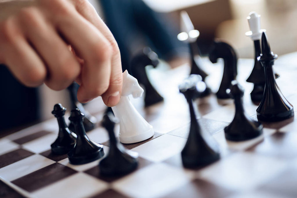 Close-up schaakbord met witte ridder omgeven door zwarte cijfers. - Foto, afbeelding