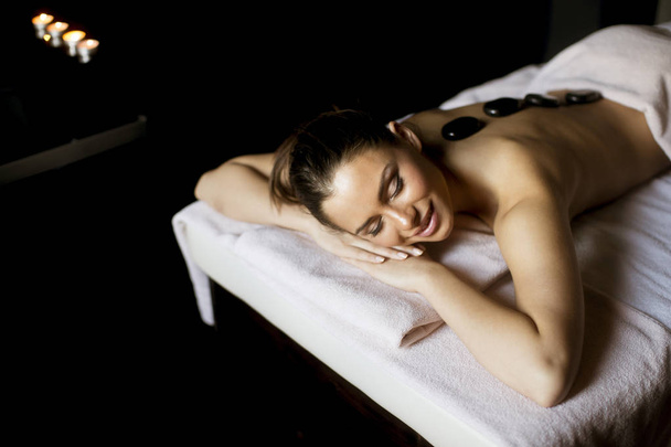 Bella giovane donna con una terapia di massaggio con pietre calde
 - Foto, immagini