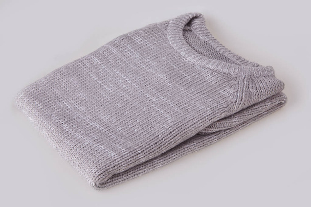 Gray folded knitted sweater with blank tag on white background. Clothes, fashion concept. Long sleeve tunic - Photo, Image