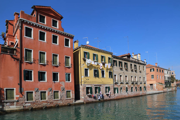 Исторические дома с прачечной висят на окнах вдоль канала, глядя на Арсенал в Венеции, Италия
 - Фото, изображение