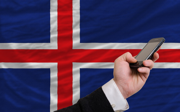 κινητό τηλέφωνο στην πρώτη εθνική σημαία της Ισλανδίας - Φωτογραφία, εικόνα