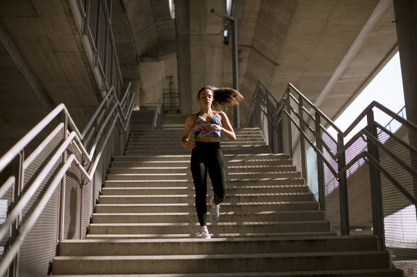 Young fitness woman doing exercises outdoor in urban enviroment - Foto, Imagen