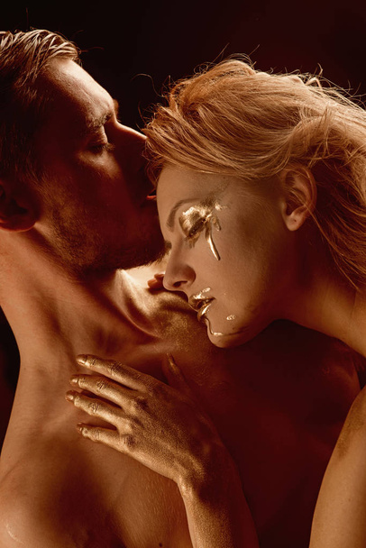 Man and woman relations. Erotic games of couple in love. Gold spa and skincare treatment. Golden collagen mask and beauty. 24K Gold. Sexy couple with golden body art makeup. - Photo, Image