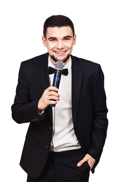 стильный элегантный мужчина в черном костюме с микрофоном в руке
 - Фото, изображение