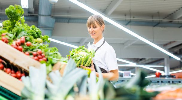 Meyve ve sebze sıralama bir süpermarkette çalışan kadın - Fotoğraf, Görsel