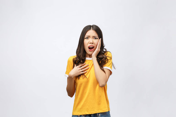 Portrait of nice shocked positive cute young girl in casual yellow shirt, opened mouth, isolated over white background - Photo, Image