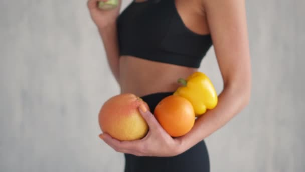 sports woman holding fresh fruits and vegetables in hands, healthy eating concept - Felvétel, videó