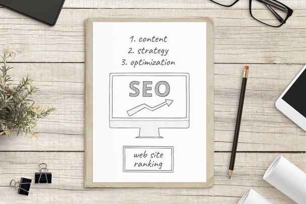 Search engine optimization sketch on white paper surrounded with office supplies. SEO web site conceito
. - Foto, Imagem