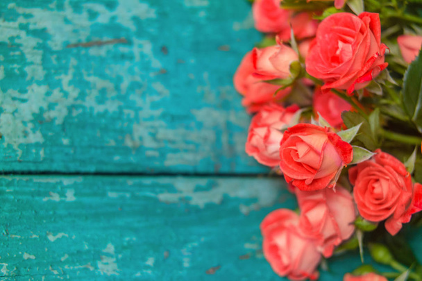 Ροζ τριαντάφυλλα σε vintage ξύλινα μπλε φόντο. Απαλή εστίαση. - Φωτογραφία, εικόνα