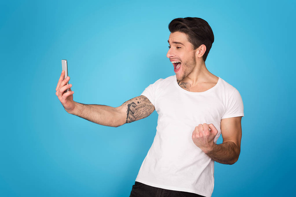 Hombre alegre con teléfono móvil celebrando la victoria
 - Foto, Imagen