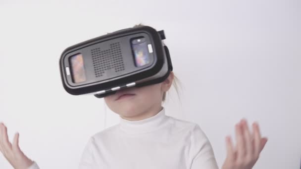 Little girl in VR headset at white background. Portrait of happy child - Footage, Video