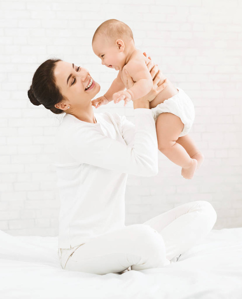 Jeune maman tenant son bébé heureux dans l'air
 - Photo, image