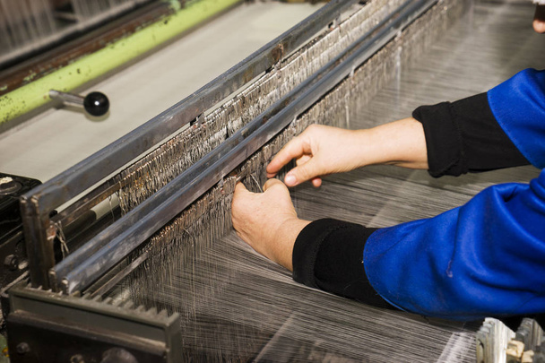 Un lavoro femminile che lavora presso la fabbrica locale incombente con macchinari attrezzature di sfondo per produrre il filo di seta colorato per l'industria tessile
. - Foto, immagini