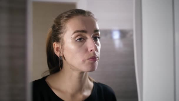 girl with acne on the face is a bathroom by the mirror - Záběry, video