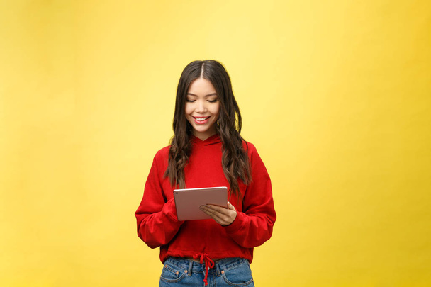 Picture of happy teenage girl with tablet pc computer isolate on yellow background - Foto, afbeelding