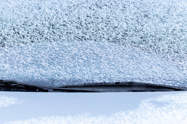 Χιόνι κάλυψε το παράθυρο του αυτοκινήτου με τους υαλοκαθαριστήρες, macro, κοντά επάνω. Αντιψυκτικό δεν χρησιμοποιήθηκε. Οχήματα στο χιόνι. Πλησιάζει η χειμερινή ώρα. Κακές καιρικές συνθήκες - Φωτογραφία, εικόνα
