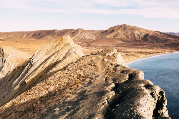 Uçurumun ridge tehlikeli dar yolda. Görünüm Karadeniz kıyısında, güneşli bir sabah sarı ve kahverengi tepelerde. Cape bukalemun, Koktebel, Crimea - Fotoğraf, Görsel