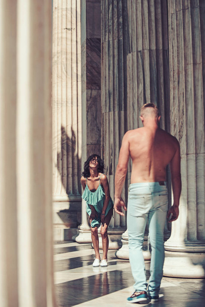 Date of sexy woman and man. Love relations of sexy couple at summer day among ancient columns. Summer holidays and travel vacation. Couple in love show summer fashion. Family and valentines day - Fotografie, Obrázek
