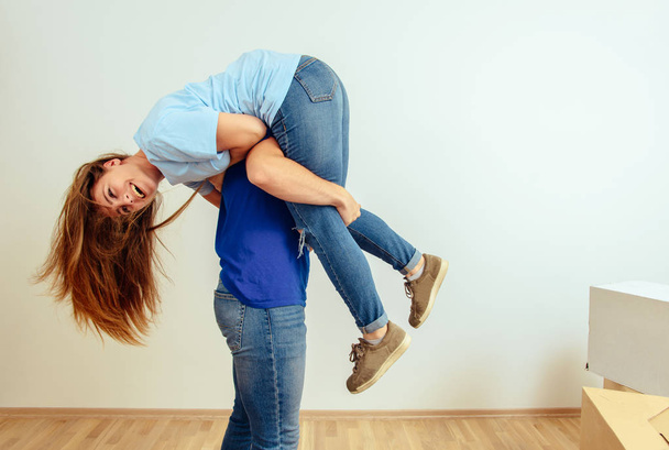 Young positive couple having fun in their new apartment - Foto, Imagem